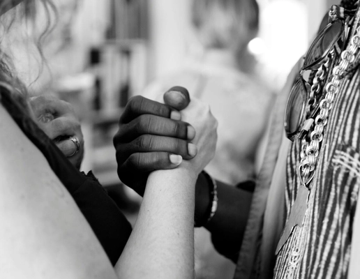 A zoomed-in black and white photograph of a black and white woman holding hands A zoomed-in black and white photograph of a black and white woman holding hands
