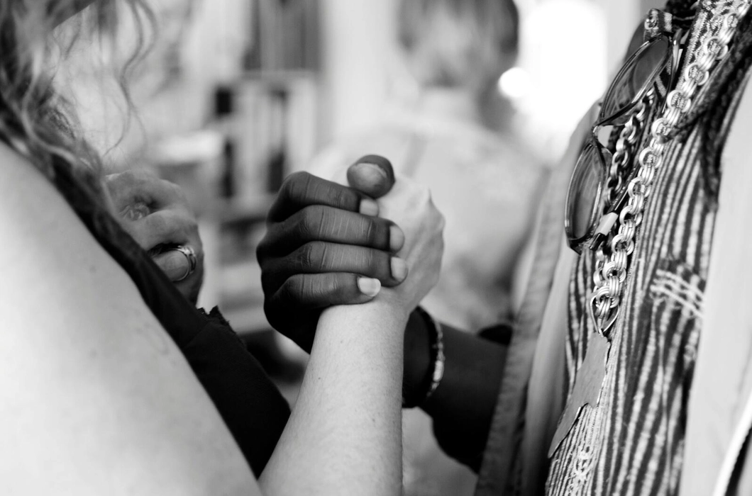A zoomed-in black and white photograph of a black and white woman holding hands A zoomed-in black and white photograph of a black and white woman holding hands