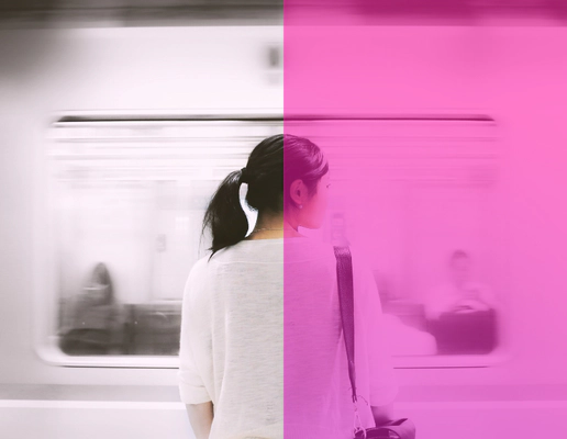 A woman standing on a platform facing a moving train. A woman standing on a platform facing a moving train.