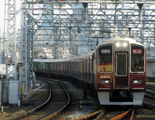 A picture of a dark red Hankyu train on the tracks at Osaka Railway Station. A picture of a dark red Hankyu train on the tracks at Osaka Railway Station.