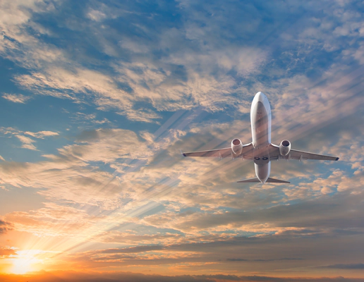 A picture of a white passenger plane from below, against a blue sky filled with clouds and a lens flare from the sun A picture of a white passenger plane from below, against a blue sky filled with clouds and a lens flare from the sun
